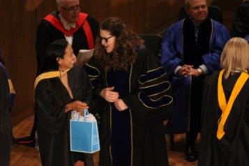 Senior sociology major Laura Velazquez (left) is robed by Dr. Alison Simons. Photo by Hannah Onder